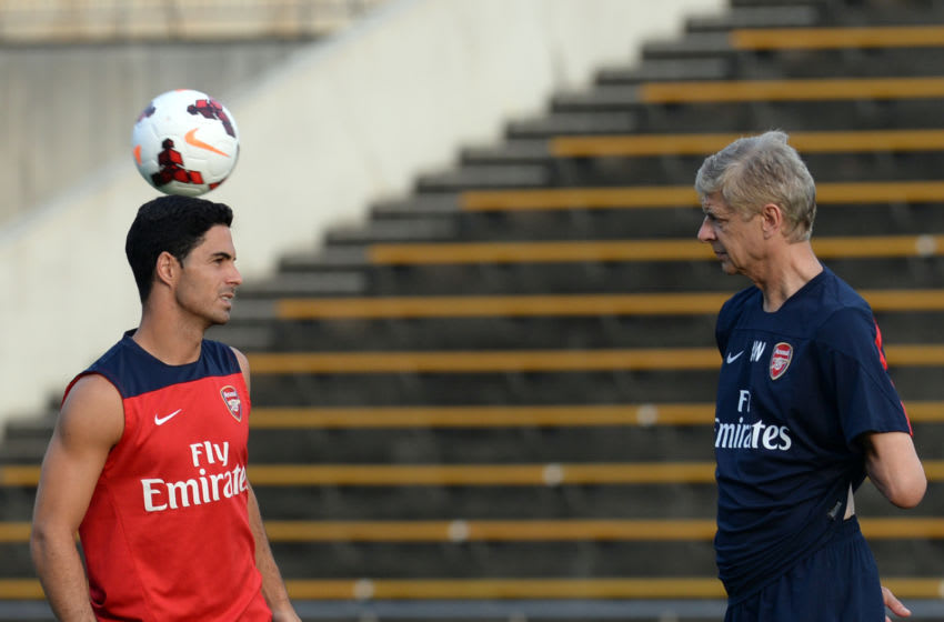 Arsenal midfielder Mikel Arteta (L) chats with head coach Arsene Wenger (R) during their training session in Nagoya on July 21, 2013. Arsenal's Japanese leg of their pre-season Asian tour is a trip down memory lane for Arsene Wenger, as he faces former club Nagoya Grampus -- coached by one of his ex-players. AFP PHOTO / TOSHIFUMI KITAMURA (Photo credit should read TOSHIFUMI KITAMURA/AFP via Getty Images)